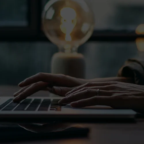 A person writing a blog post on a laptop