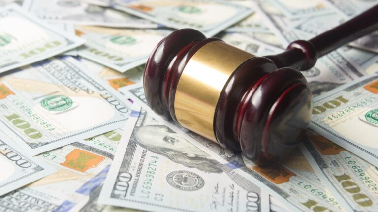 Judge gavel on the dollar cash background