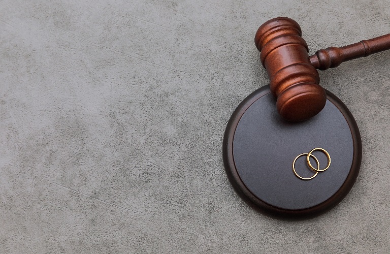 Judge gavel wedding rings on concrete stone grey background