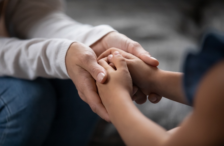 mother is holding hands of little kid girl