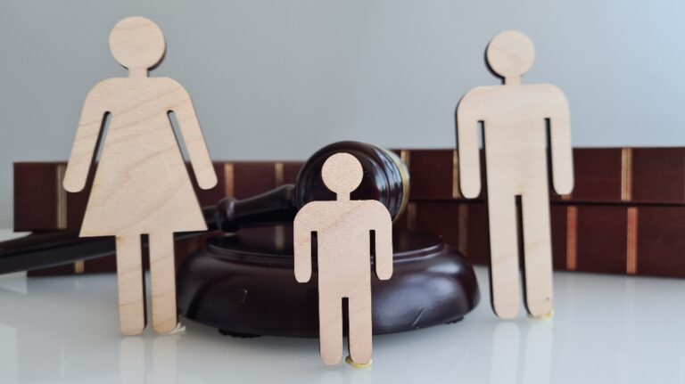Wooden figures representing a family near a judge's gavel