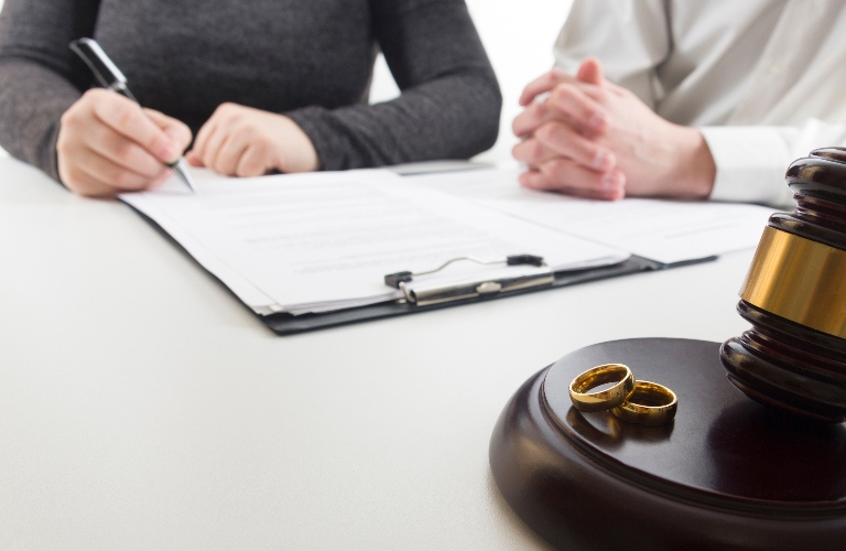 Hands of wife, husband signing decree of divorce